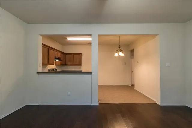 an empty room with wooden floor and cabinet
