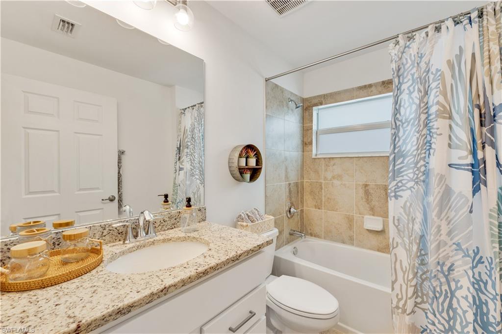 43041 Greenway Boulevard, Unit 921 Babcock Ranch, FL 33982 - Photo 13 of 15 a bathroom with a granite countertop sink toilet and shower