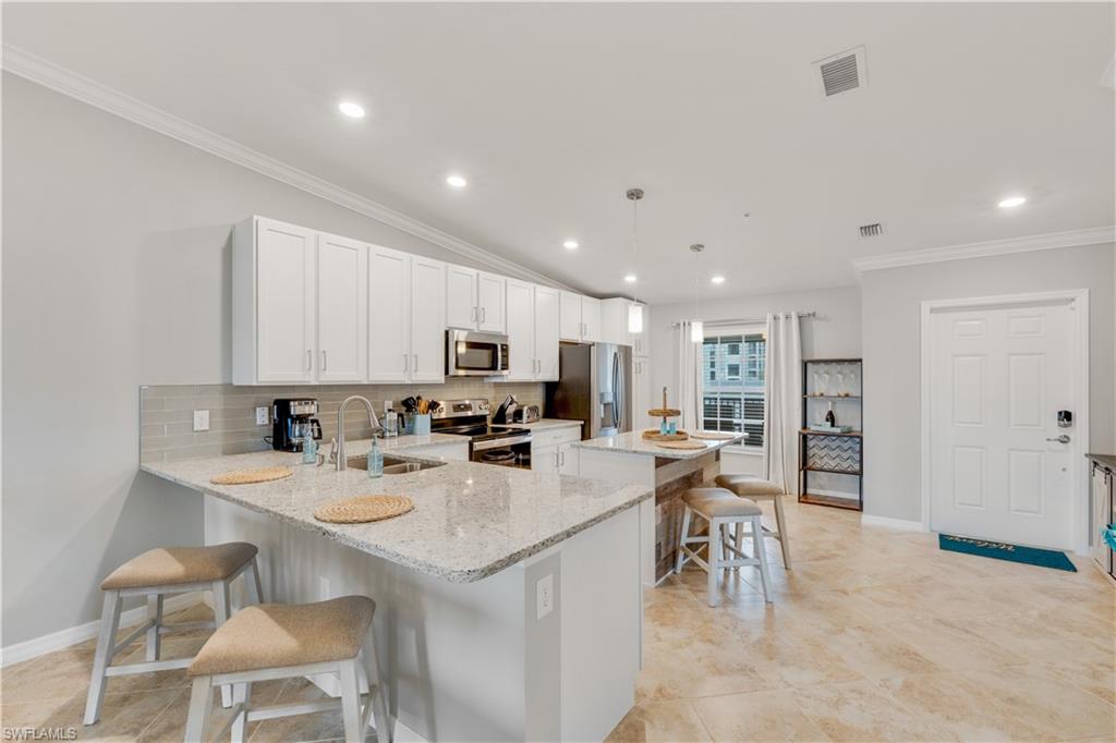 43041 Greenway Boulevard, Unit 921 Babcock Ranch, FL 33982 - Photo 3 of 15 a kitchen with appliances a sink a counter top space and cabinets
