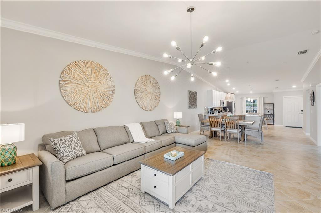43041 Greenway Boulevard, Unit 921 Babcock Ranch, FL 33982 - Photo 7 of 15 a living room with furniture a large window and a chandelier