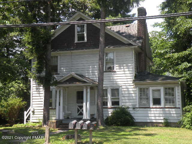 a front view of a house with a yard and potted plants