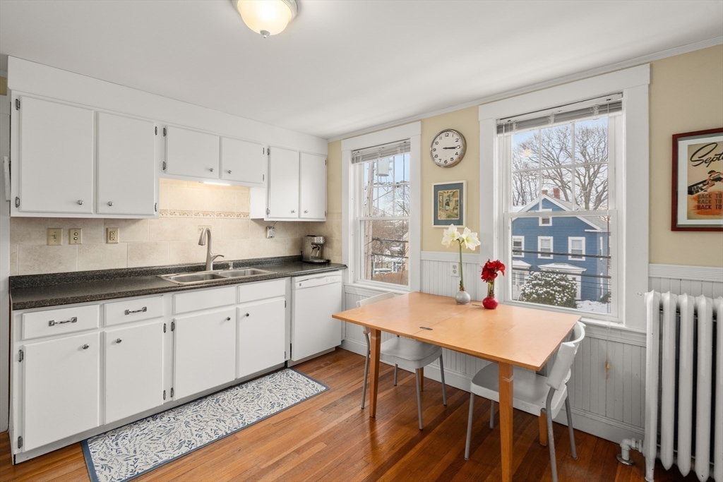 4 Albano Street, Unit 2 Boston, MA 02131 - Photo 11 of 24 a kitchen with granite countertop white cabinets and chairs