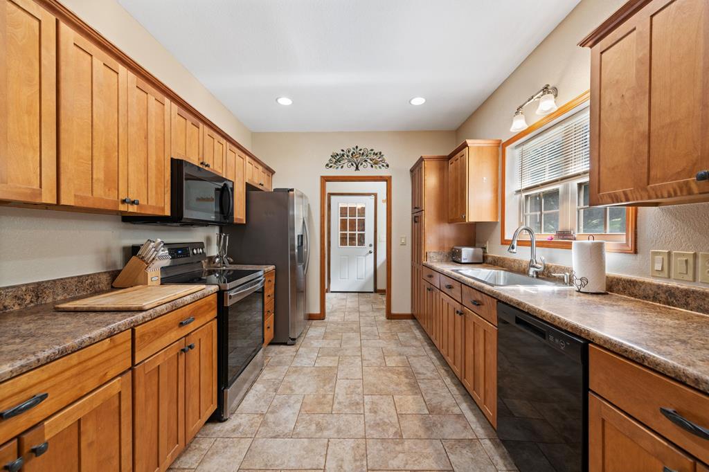 516 Crawford Road Blairsville, GA 30512 - Photo 16 of 49 a large kitchen with stainless steel appliances granite countertop a stove top oven a sink dishwasher and a microwave oven with large wooden cabinets