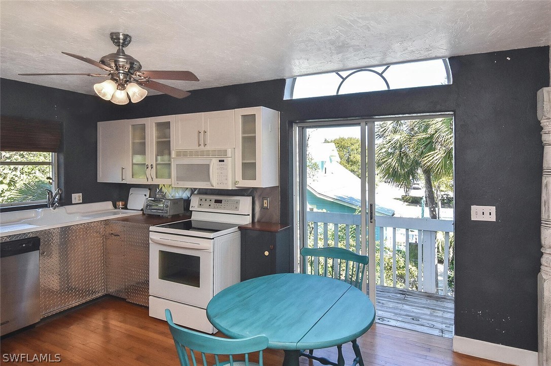 2480 Library Way Sanibel, FL 33957 - Photo 12 of 33 a kitchen with a stove a microwave and wooden floor