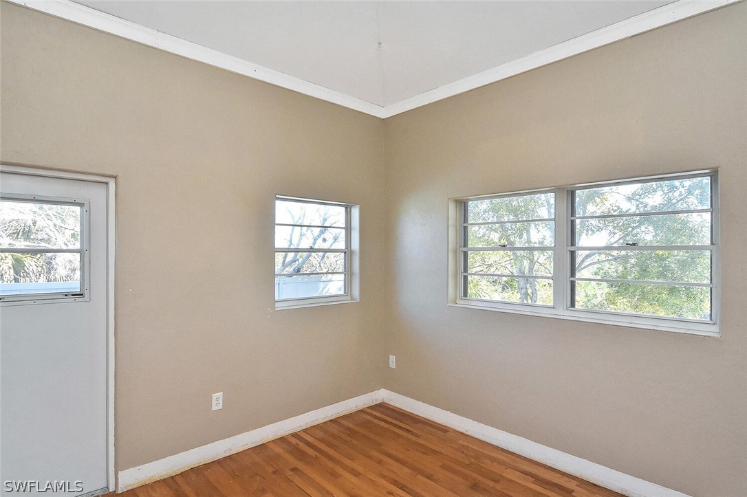 2480 Library Way Sanibel, FL 33957 - Photo 16 of 33 a view of an empty room with wooden floor and a window