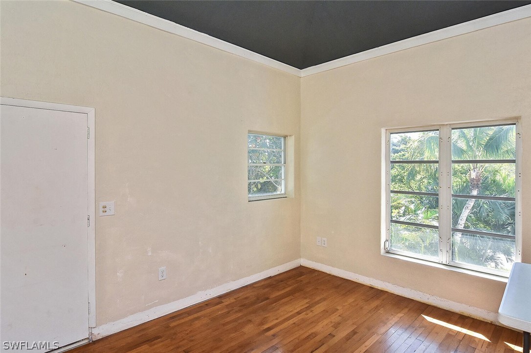 2480 Library Way Sanibel, FL 33957 - Photo 18 of 33 a view of an empty room with wooden floor and a window