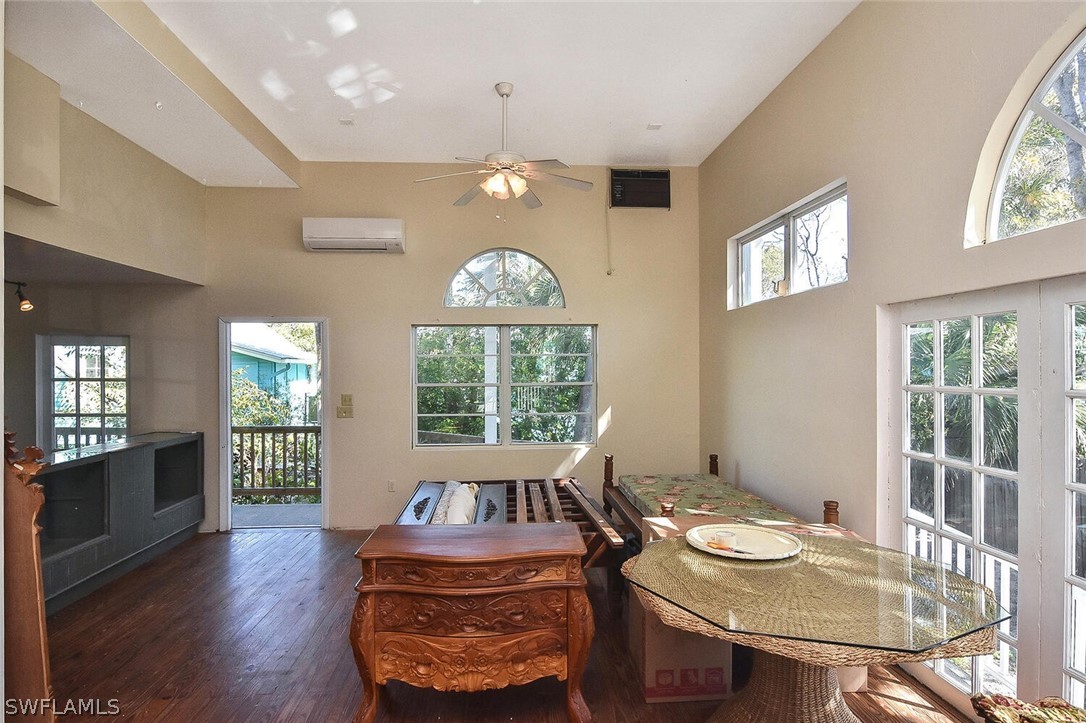 2480 Library Way Sanibel, FL 33957 - Photo 5 of 33 a dining room with wooden floor a chandelier a wooden table and chairs