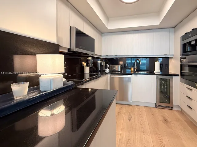 a kitchen with stainless steel appliances kitchen island granite countertop a stove a sink and a microwave