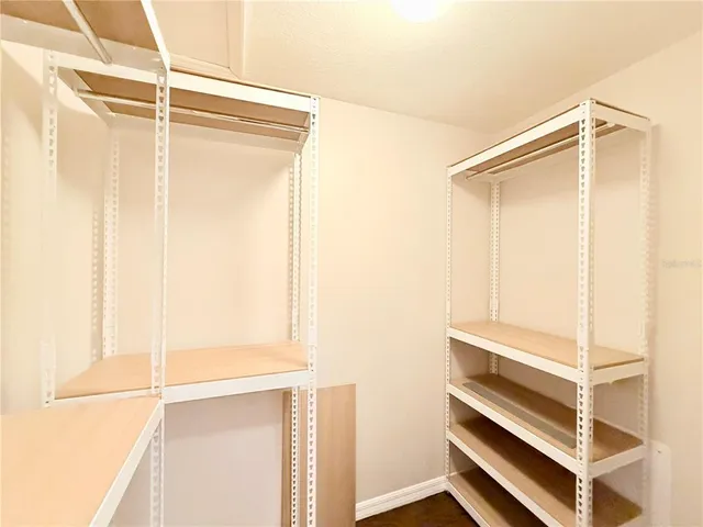 a view of walk in closet with empty racks