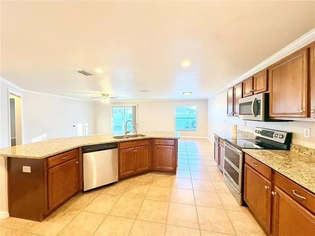a kitchen with stainless steel appliances granite countertop a sink and a stove top oven