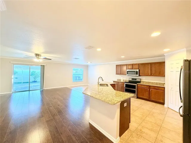 a view of a living room a kitchen with a wooden floor and a kitchen
