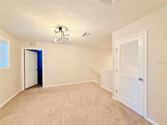an empty room with a window and a ceiling fan