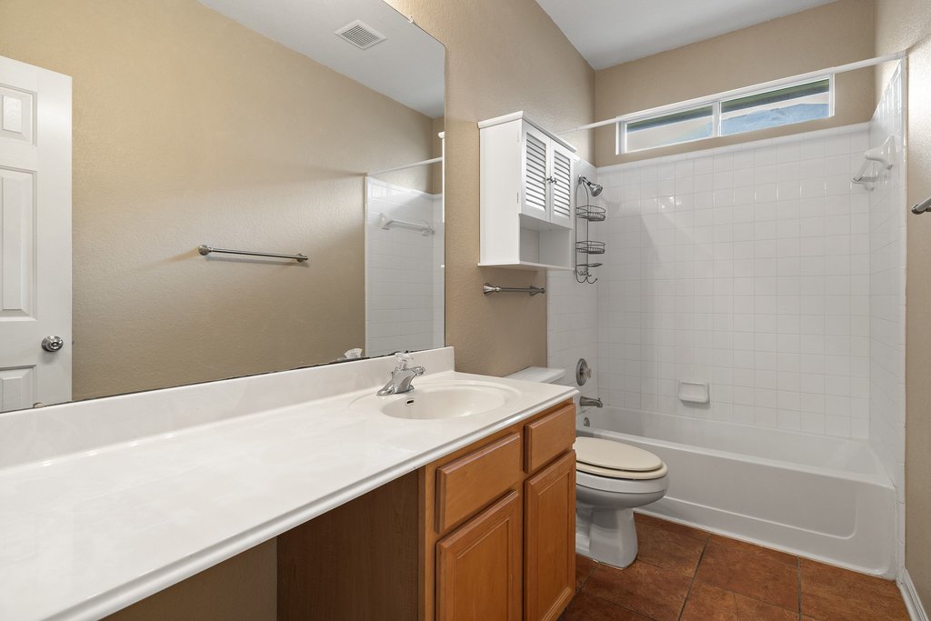 347 Spring Drive Kyle, TX 78640 - Photo 26 of 40 A well-appointed bathroom offers a convenient vanity, full-size bathtub, and practical storage solutions.