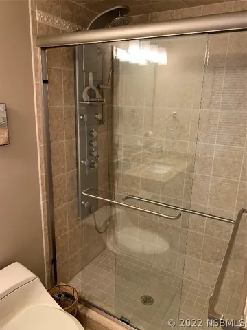 a bedroom with two beds lamp and a potted plant