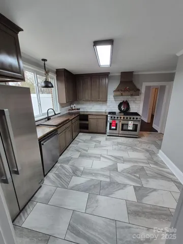 a kitchen with stainless steel appliances a sink a stove and a refrigerator