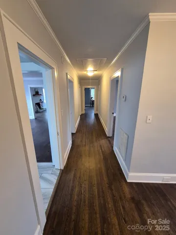 a view of a hallway with wooden floor and staircase