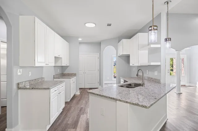 a kitchen with granite countertop kitchen island a sink appliances and cabinets