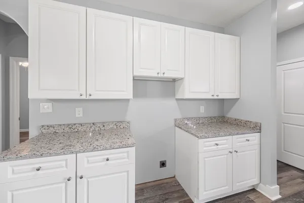 a kitchen with granite countertop white cabinets and white appliances