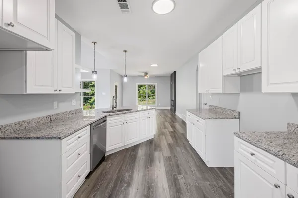 a kitchen with granite countertop white cabinets and white appliances