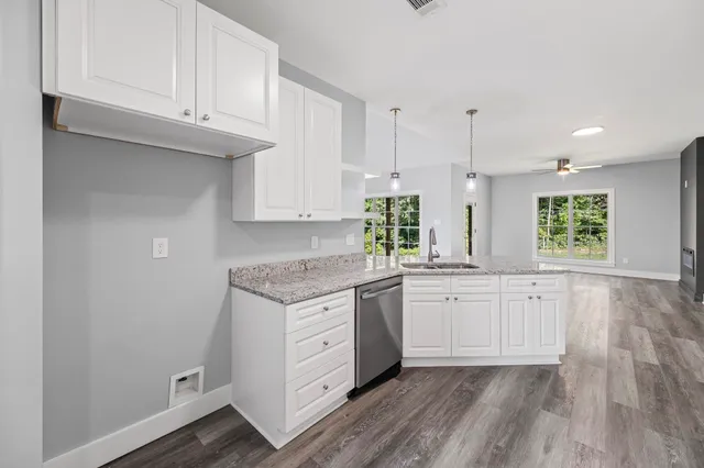 a kitchen with granite countertop white cabinets and white appliances
