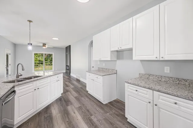 a kitchen with granite countertop white cabinets and white appliances