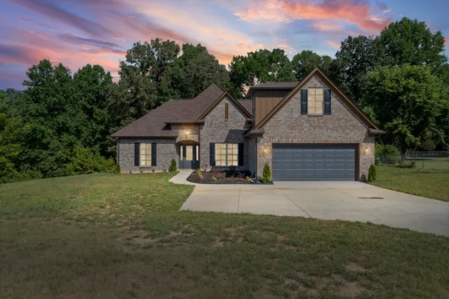 a front view of a house with a yard and trees