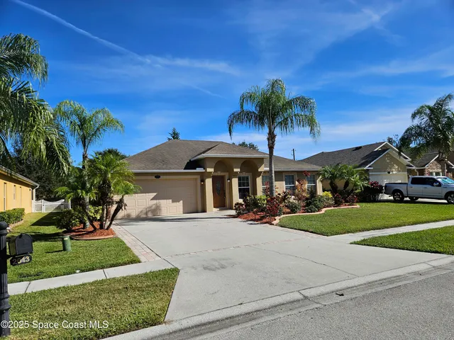 a view of a house with a yard and potted plants