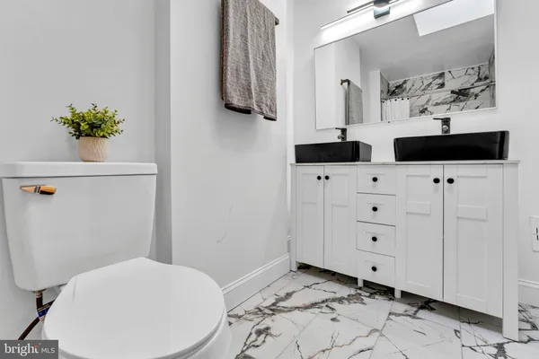 a bathroom with a sink a toilet and mirror