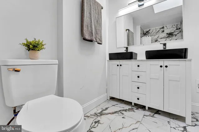 a bathroom with a sink a toilet and mirror