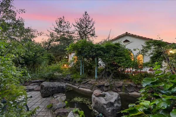 a view of a dining room and livingroom with furniture wooden floor and a chandelier