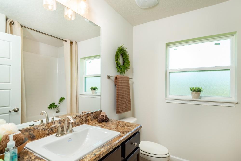 551 Quarry Lane Sebastian, FL 32958 - Photo 11 of 23 a bathroom with a granite countertop sink toilet and mirror