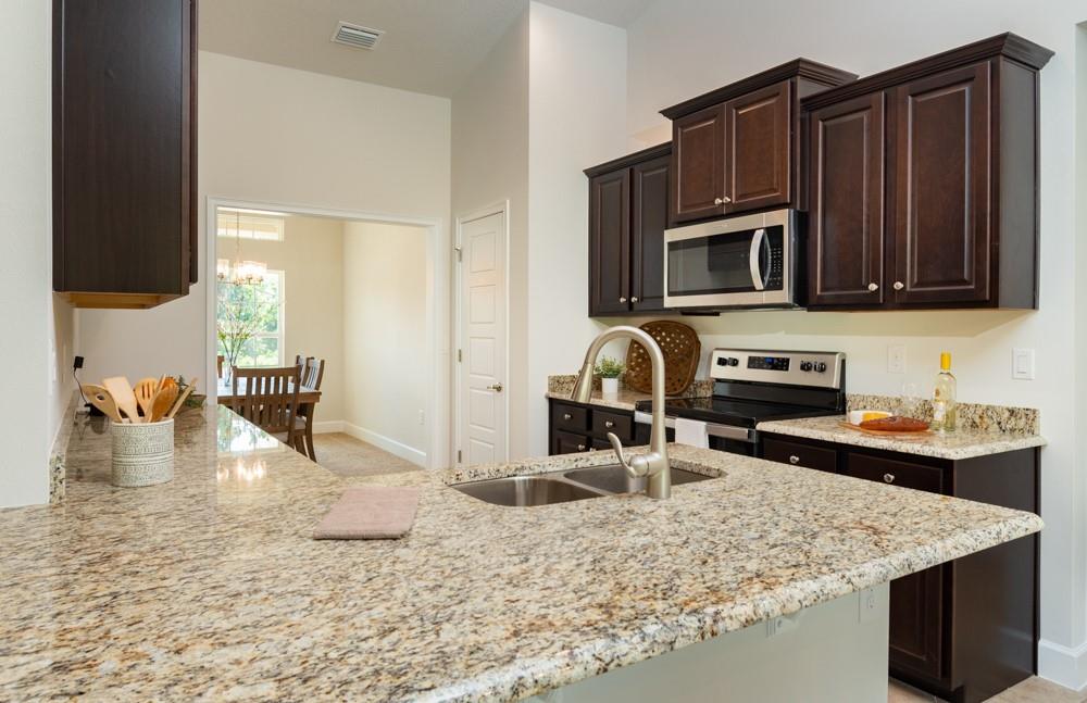 551 Quarry Lane Sebastian, FL 32958 - Photo 14 of 23 a kitchen with a sink a stove and a microwave