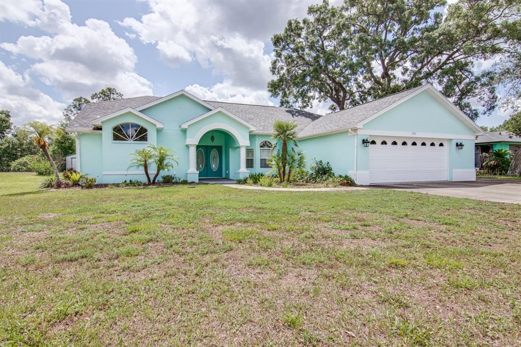 1402 Meadow Lark Road Spring Hill, FL 34608 - Photo 1 of 1 a front view of house with yard and green space