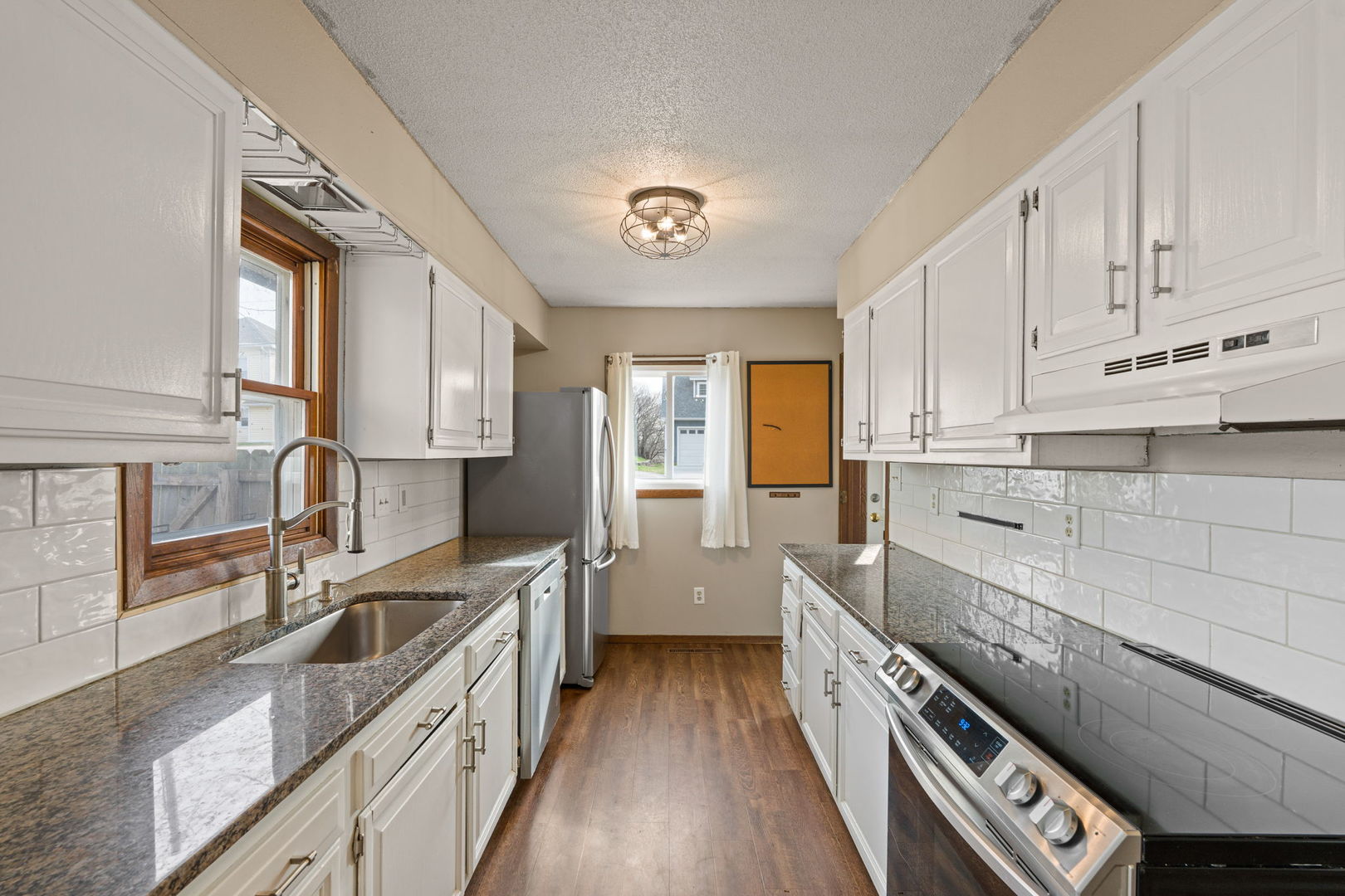 214 South 3rd Street Le Claire, IA 52753 - Photo 11 of 40 a kitchen with stainless steel appliances a sink stove and cabinets