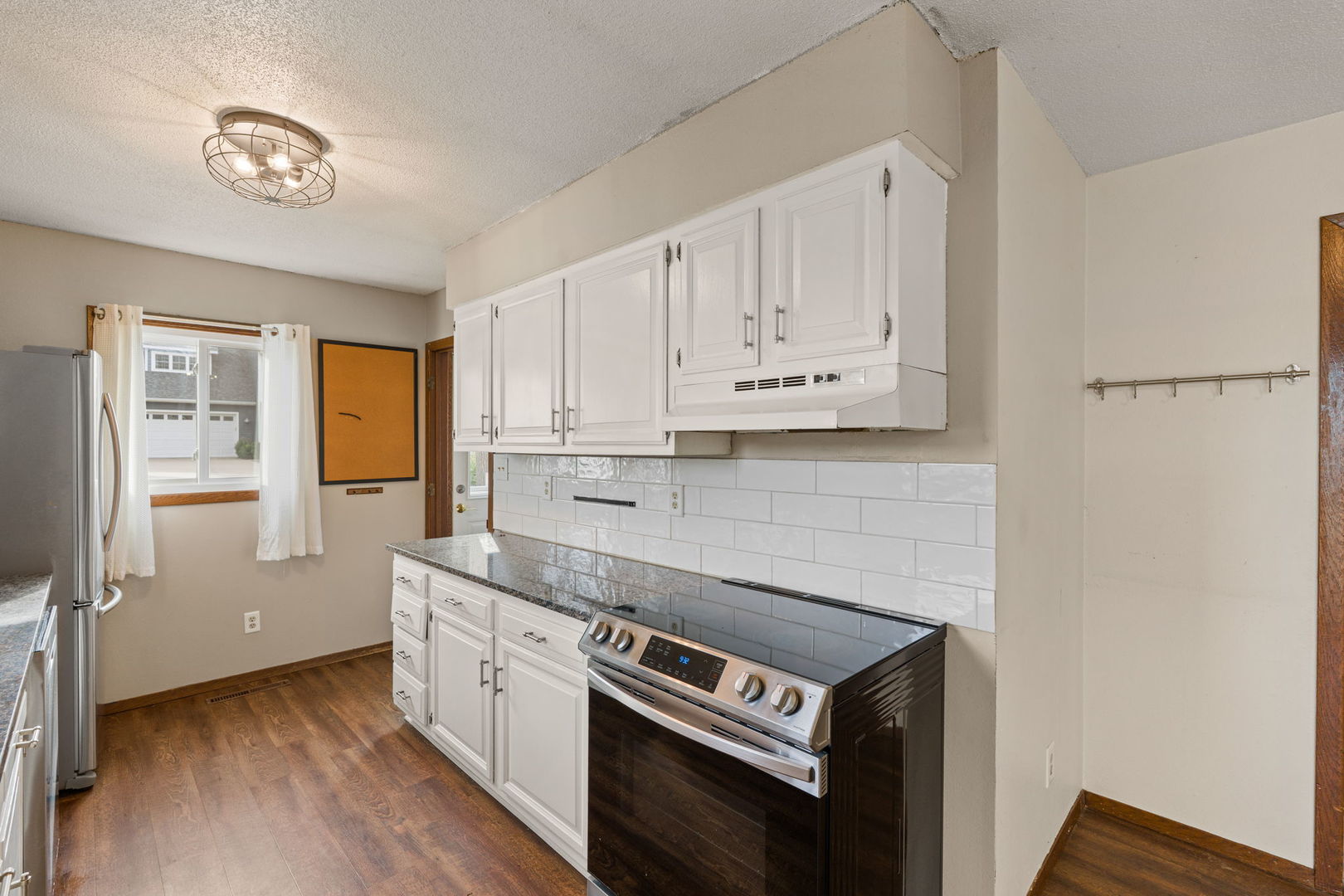 214 South 3rd Street Le Claire, IA 52753 - Photo 12 of 40 a kitchen with stainless steel appliances white cabinets and a stove