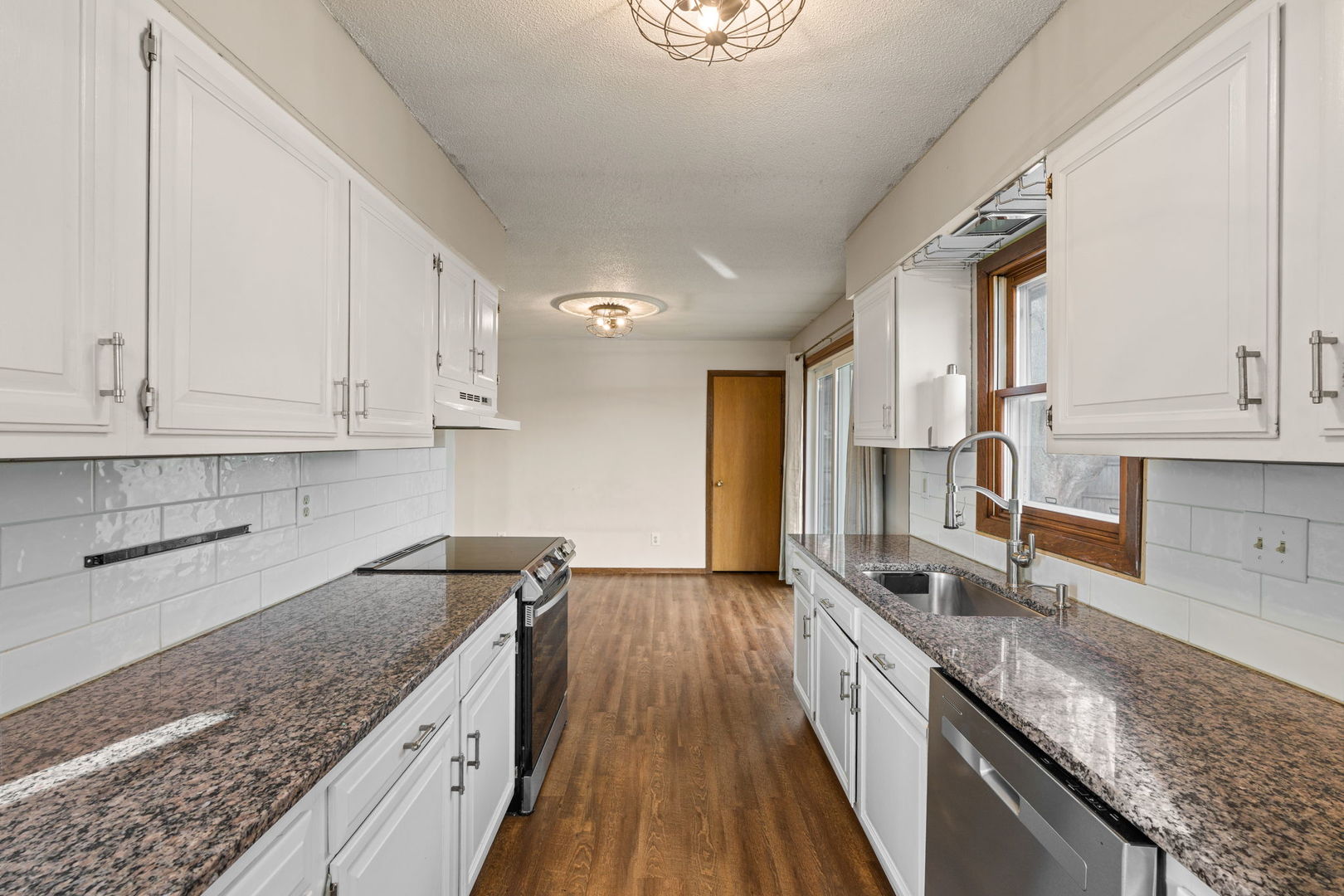 214 South 3rd Street Le Claire, IA 52753 - Photo 14 of 40 a kitchen with granite countertop a sink a counter space and cabinets