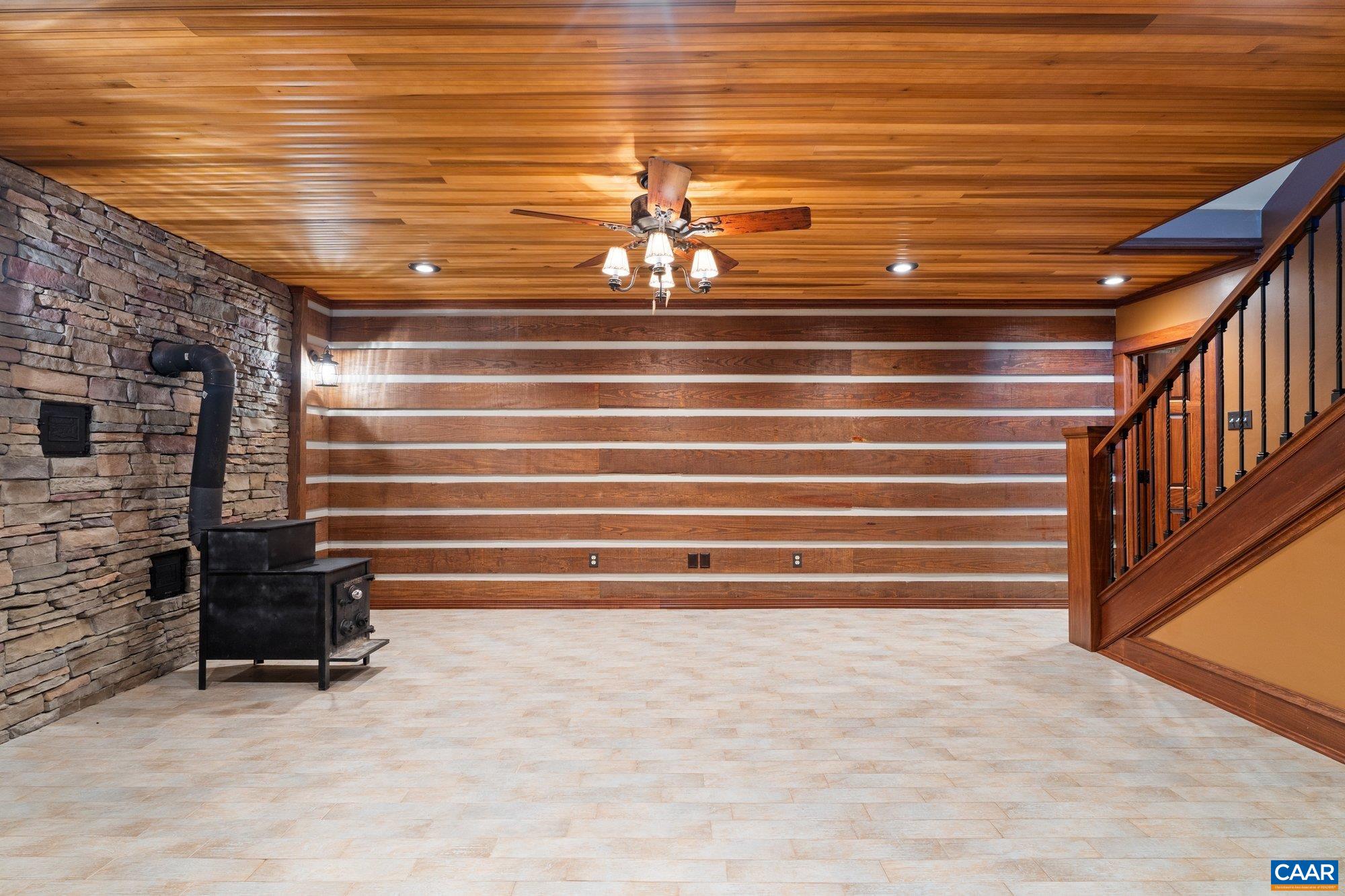 884 Pleasant Gap Drive Dry Fork, VA 24549 - Photo 44 of 72 Hand-chinked log wall. Slate wall behind wood-burning stove. Solid wood paneled ceiling.