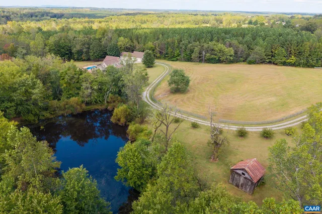 a view of a livingroom with wooden floor a ceiling fan and kitchen space