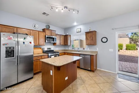 a kitchen with stainless steel appliances granite countertop a refrigerator a stove a sink and a microwave