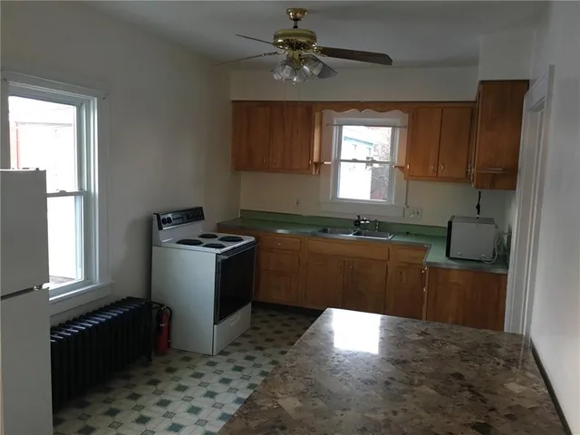 a kitchen with granite countertop a stove a sink and a window