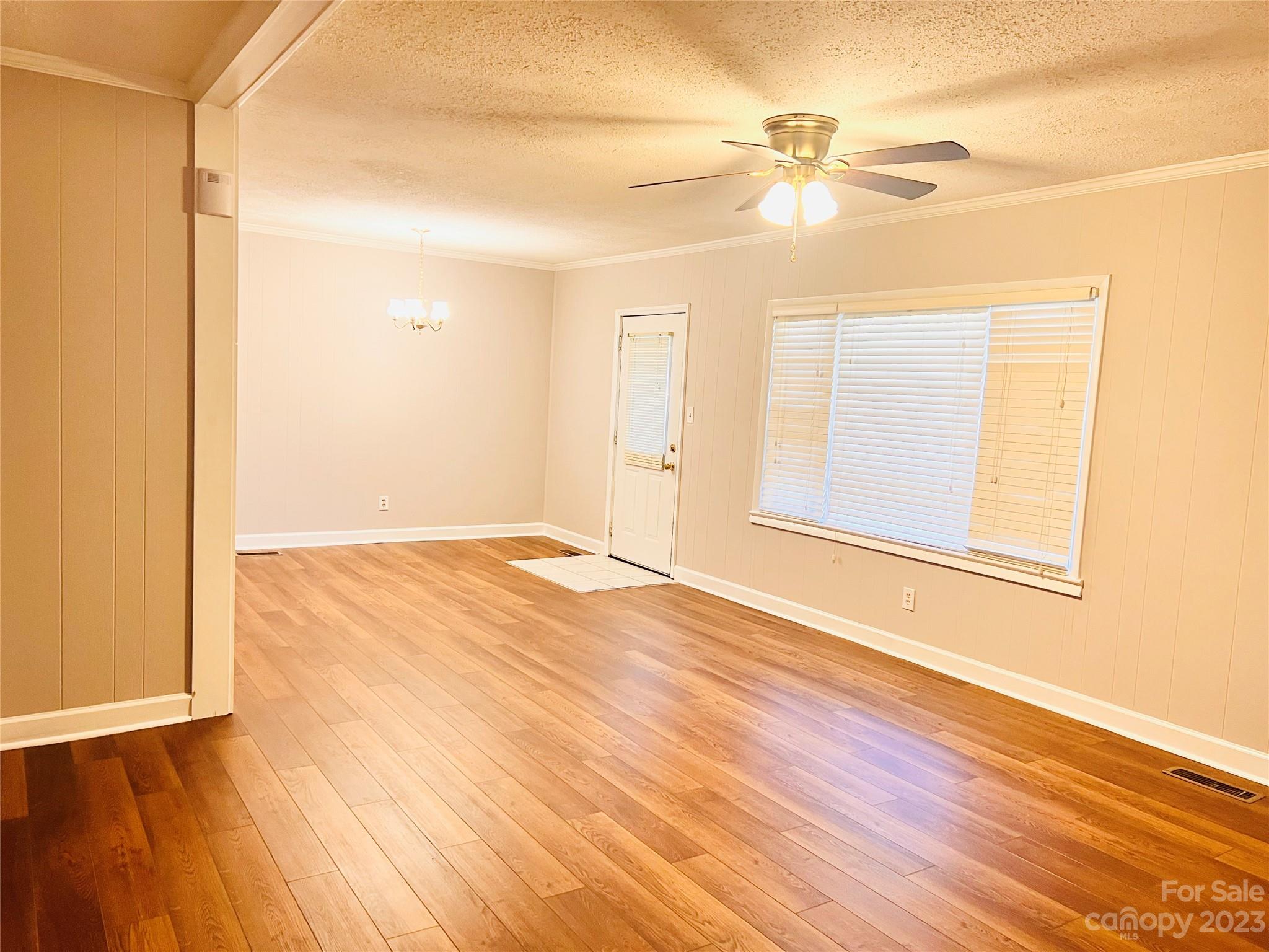 207 7th Avenue Southwest Conover, NC 28613 - Photo 4 of 12 an empty room with wooden floor fan and windows