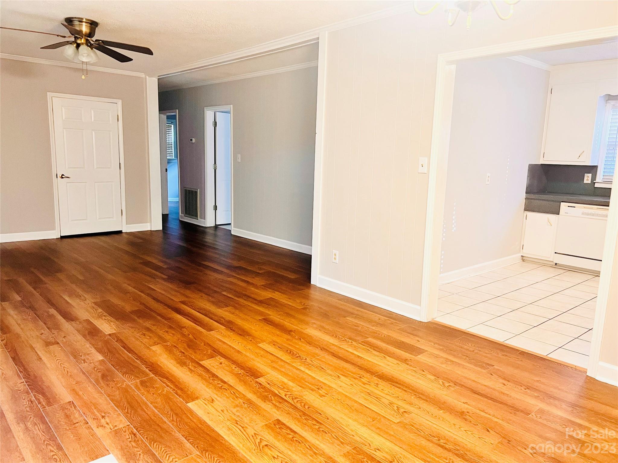 207 7th Avenue Southwest Conover, NC 28613 - Photo 7 of 12 a view of an empty room with wooden floor and a ceiling fan