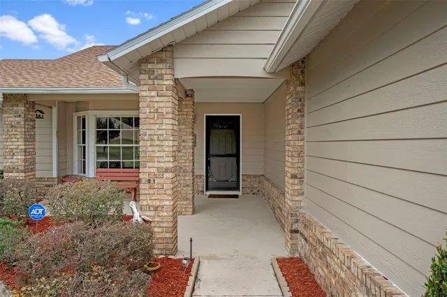 front view of a house with a large window and chair