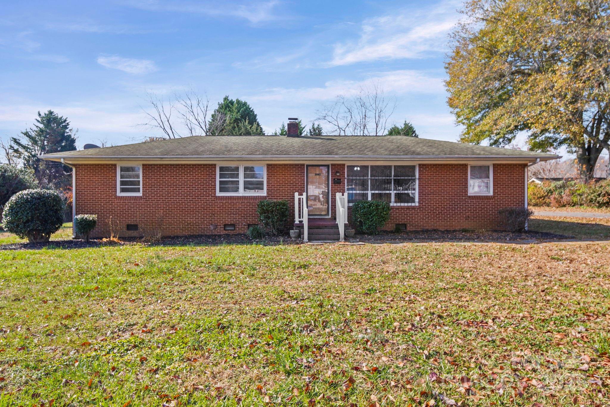 a front view of house with yard and trees around
