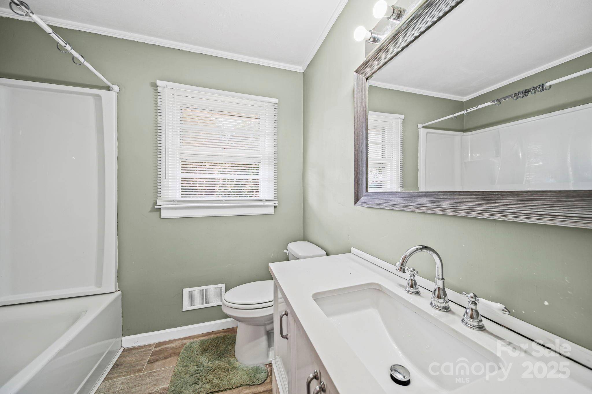 1703 East Perry Street Gastonia, NC 28054 - Photo 12 of 30 a bathroom with a sink toilet and a mirror