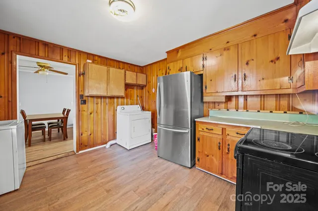 a kitchen with stainless steel appliances granite countertop a refrigerator a stove and a wooden floors