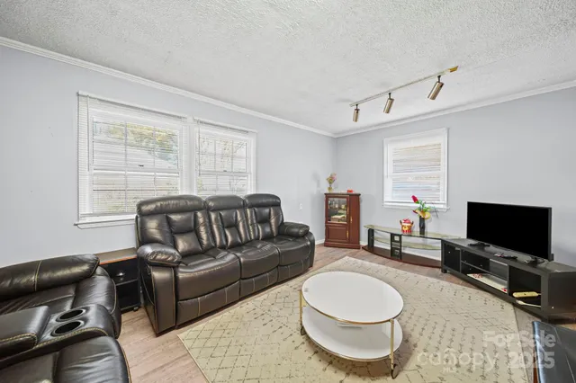 a living room with furniture a flat screen tv and a window