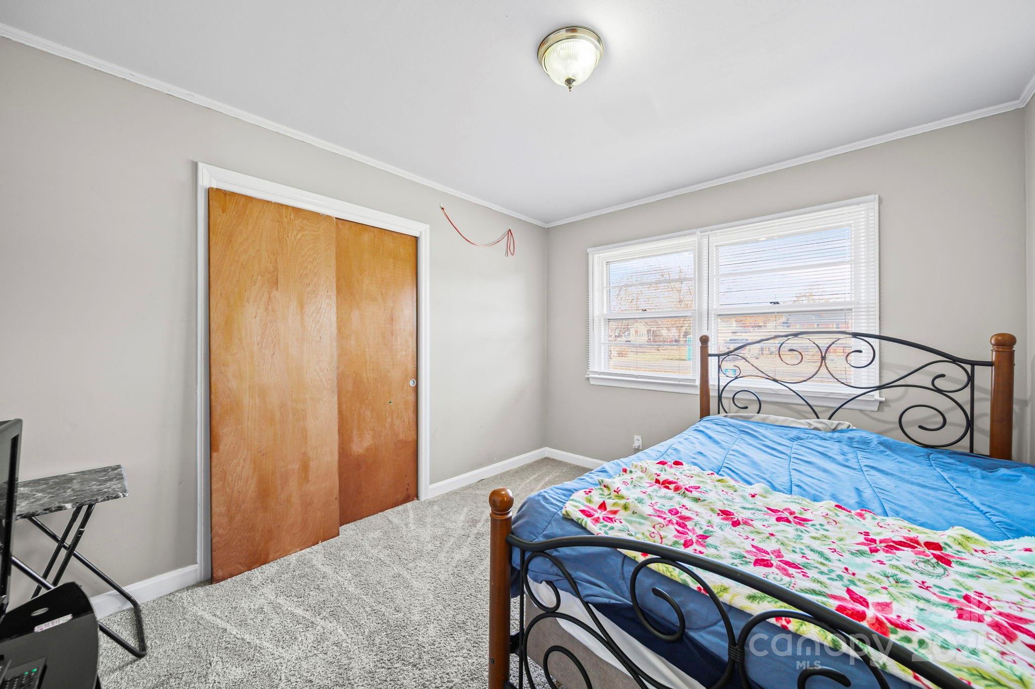 1703 East Perry Street Gastonia, NC 28054 - Photo 4 of 30 a bedroom with a bed and a table in it