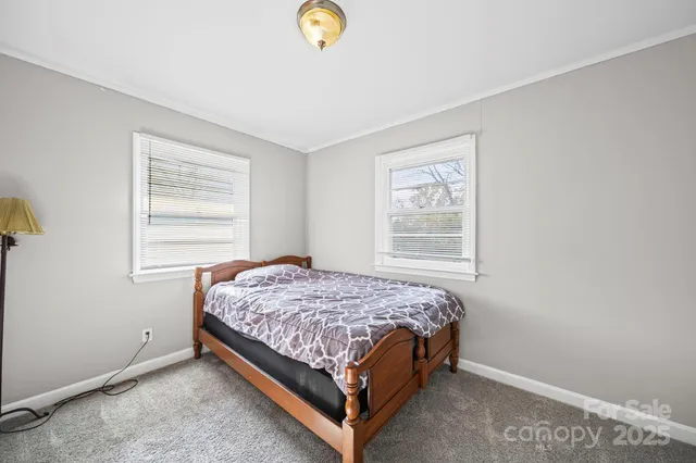 a bed sitting in a bedroom next to a window
