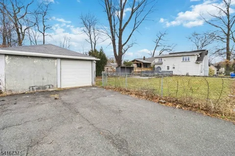 a view of a house with a yard and large tree